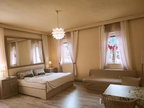 a bedroom with a bed and a chair and a mirror at Penzion Přívoz in Hřensko