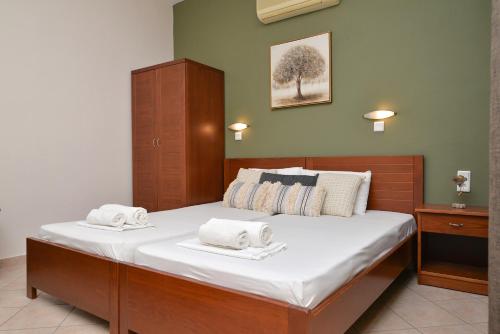 a bedroom with a large bed with two towels on it at Hotel Fani in Leptokarya