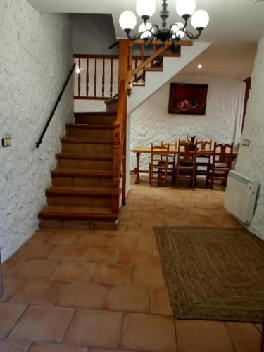 a living room with a staircase and a dining room at Cal Massana in Sant Guim de la Plana