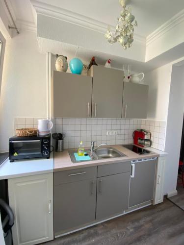 a kitchen with a sink and a microwave at Haus Frauenpreiss 67 in Cuxhaven