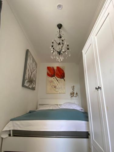 a small bedroom with a bed and a chandelier at Haus Frauenpreiss 67 in Cuxhaven