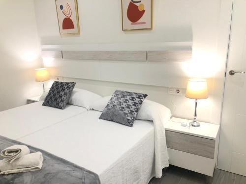 2 Betten in einem kleinen Zimmer mit 2 Lampen in der Unterkunft Apartamento Air Blanc Maracena Centro in Maracena