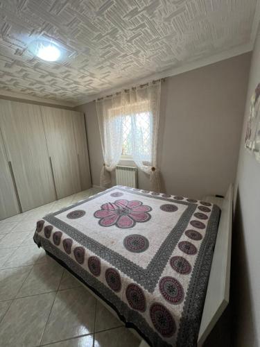 Un dormitorio con una cama con una manta de flores. en SEA apartment, en Fiumicino