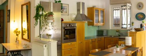 a kitchen with wooden cabinets and a table in it at Blossom Apartment Kos in Ampavris