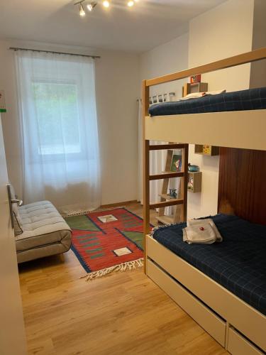 a bedroom with two bunk beds and a rug at Seewohnung Lucia - mit Seezugang in Annenheim