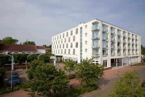 a white building with a parking lot in front of it at ConventGarten Hotel & Restaurant - am Nord-Ostsee-Kanal in Rendsburg