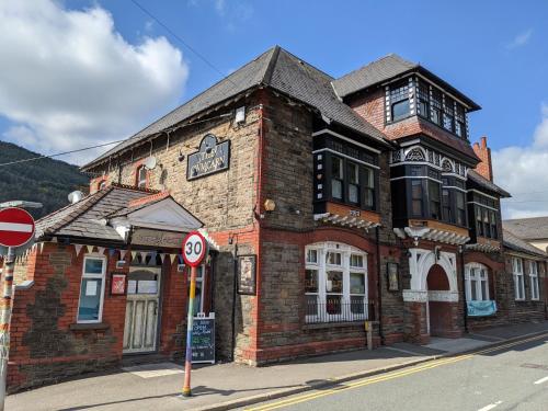 an old brick building on the corner of a street at Cwmcarn Hotel & Bunkhouse in Cwmcarn