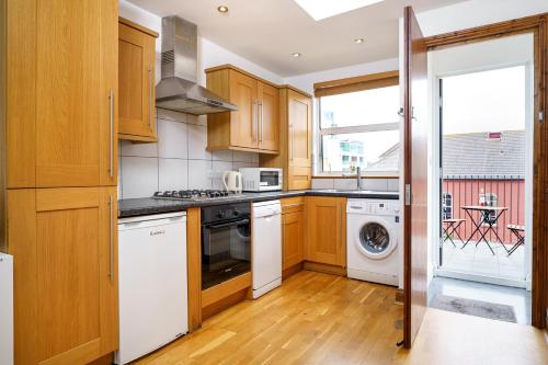 a kitchen with wooden cabinets and white appliances at Flat in London in London
