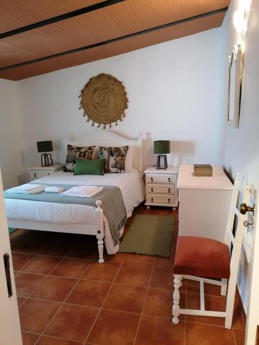 a bedroom with a bed and a table and a chair at A casa da Carolina II in Mértola