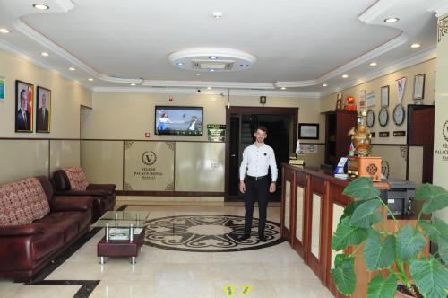 a man standing in a waiting room in a hotel room at Vilesh Palace Hotel in Masallı