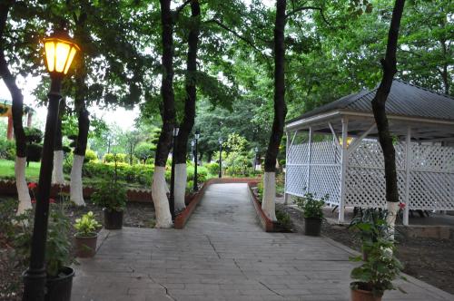 a walkway in a park with a gazebo at Vilesh Palace Hotel in Masallı