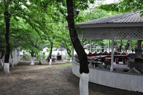 a gazebo with picnic tables in a park at Vilesh Palace Hotel in Masallı