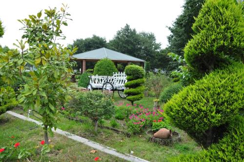 a garden with a white carriage in the middle at Vilesh Palace Hotel in Masallı