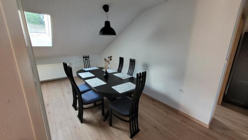 comedor con mesa negra y sillas en Apartma Krupa, en Gradac