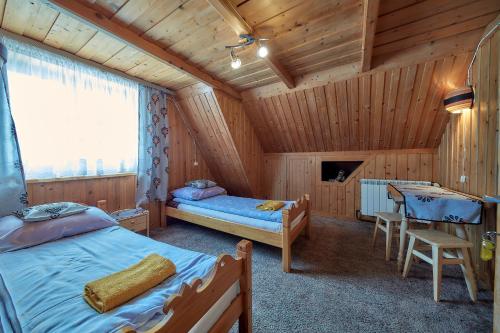 sypialnia z 2 łóżkami i stołem w obiekcie Schodami do nieba w Zakopanem