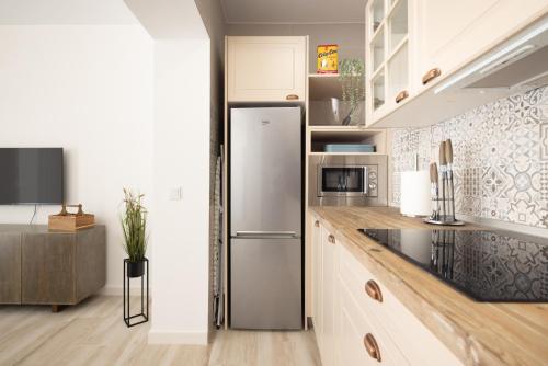 a kitchen with a stainless steel refrigerator in a room at Suite Catedral Little Apartments in Cádiz