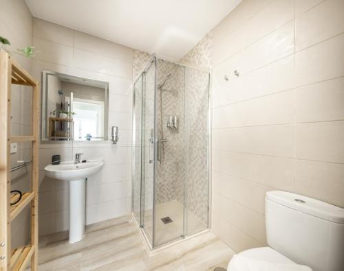 a bathroom with a shower and a toilet and a sink at Suite Catedral Little Apartments in Cádiz