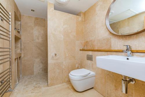 ein Badezimmer mit Toilette, Waschbecken und Spiegel in der Unterkunft Poundgate Park Cottage in Crowborough