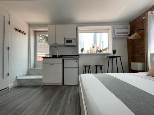 a small room with a bed and a kitchen with a kitchen at Hotel and the City, Rooftop City View in New York