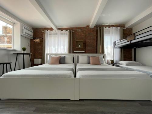 a bedroom with three beds in a room at Hotel and the City, Rooftop City View in New York