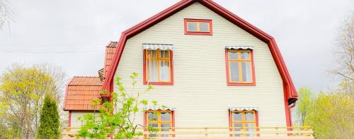 Casa blanca grande con ventanas rojas en Hemma hos Jeanette & Micke på Peresgården, en Vikarbyn