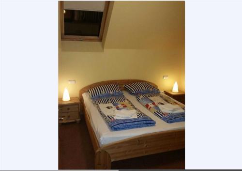 - une chambre avec un lit avec deux oreillers et deux lampes dans l'établissement Karlshagen, Hafenidyll Fewo Dörte, à Karlshagen