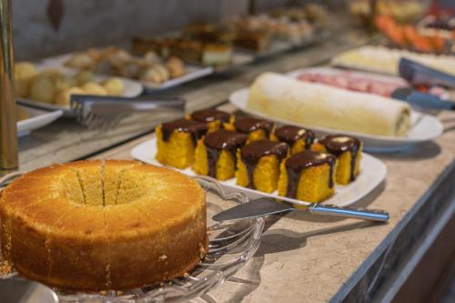 a table topped with plates of food and a cake at Le Suisse Elegance Hotel in Campos do Jordão
