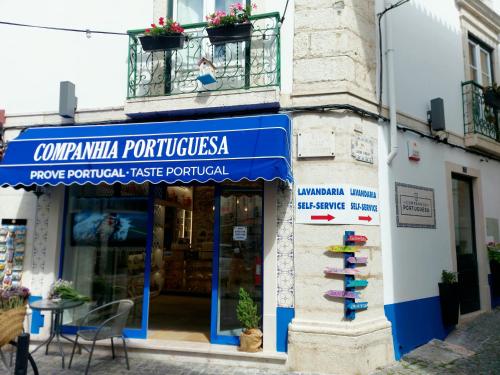 a store with a blue sign on the side of a building at Residenza Dutzu - Aparthotel Leiria in Leiria