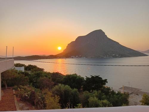 a view of a mountain with the sun setting over the water at Ariadne Studios in Kalymnos
