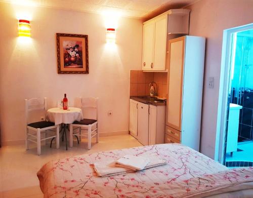 a kitchen with a table and a bed in a room at Apartments FLORA and boat cruising in Virpazar