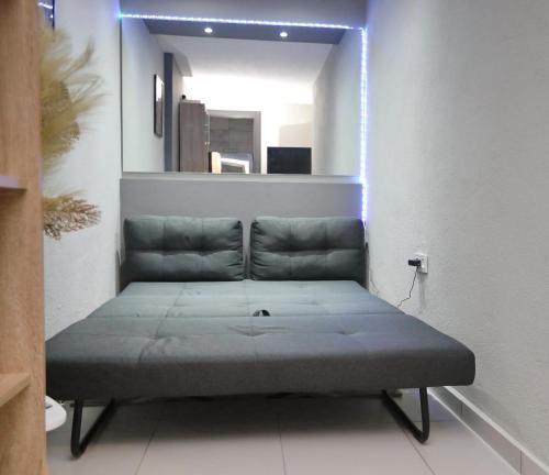 a bed in the corner of a room with a mirror at iLposto Down in Kavala