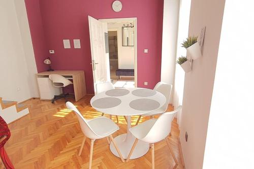 a dining room with a table and white chairs at Apartman Szeged szívében in Szeged