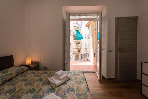 a bedroom with a bed and a door to a balcony at Dimora Francesca in Salerno
