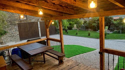 a wooden pergola with a table and a bench on a patio at T.H.NY Village Inn Cottage in Tihany