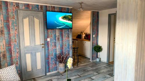 a living room with a flat screen tv on a wall at T.H.NY Village Inn Cottage in Tihany