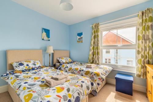 a bedroom with two beds and a window at Cabbell Towers - Norfolk Holiday Properties in Cromer