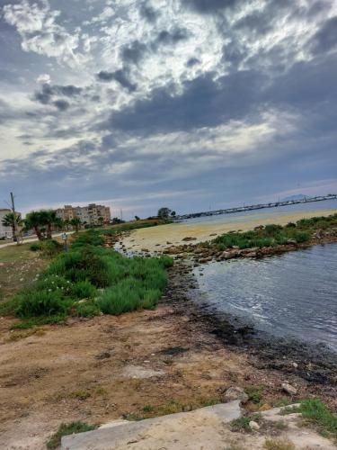 a beach with a body of water and a cloudy sky at L'APPARTAMENTO DEL MARE in Marsala