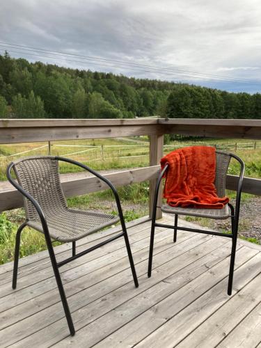 an orange blanket sitting on a chair on a deck at Asplunda Gård, Kolmården, stuga nr 3 in Kolmården