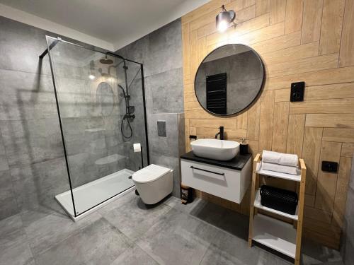 a bathroom with a toilet sink and a shower at Apartament Stylowy 2 in Leszno