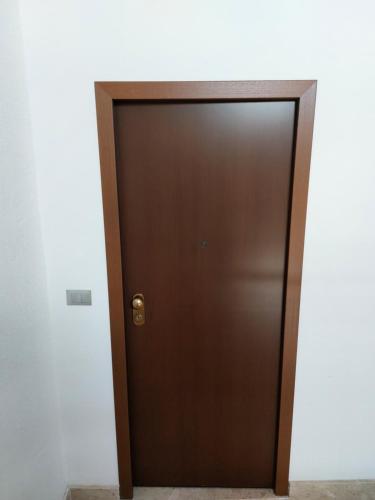 a brown elevator door in a white wall at L'APPARTAMENTO DEL MARE in Marsala
