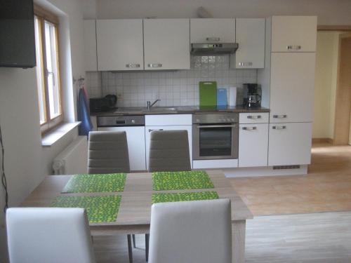 a kitchen with a table with chairs and a kitchen with white cabinets at Apartment Herdrich in Rust