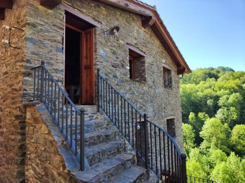 a stone building with stairs leading to a door at Allotjaments Cal Llarg in Molló