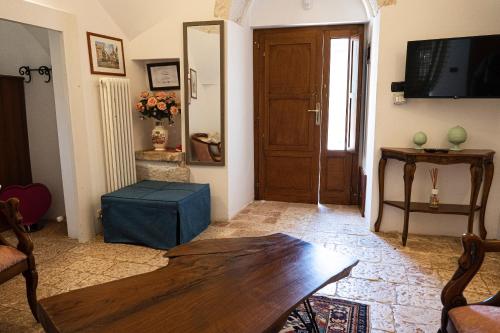 a living room with a wooden table and a door at Trullo Bianco in Putignano