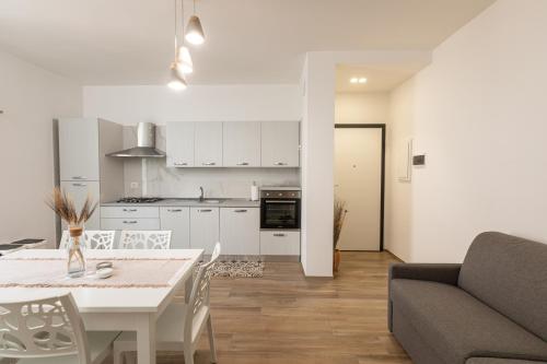 cocina y sala de estar con mesa y sofá en Appartamento L'Essenziale, en Vieste