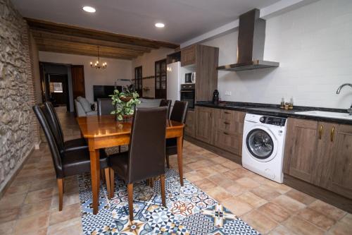 a kitchen with a wooden table and chairs and a washing machine at Casa Monferrer in Useras