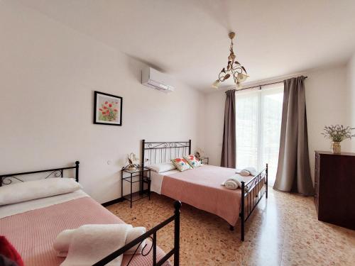 1 dormitorio con 2 camas y ventana en Agriturismo Conca Sandra - Farm Stay on Lake Como, en Perledo