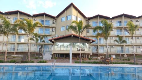 um hotel com piscina e palmeiras em Class Hotel Passos Rio Grande Portal da Canastra em Passos