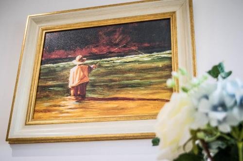 a painting of a person standing in the water at The Heights & Hollows Farmhouse, Saul, Downpatrick, SLEEPS 14 in Downpatrick