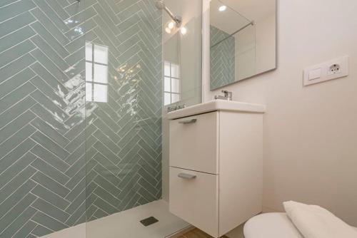 a white bathroom with a sink and a mirror at Apartamento Castellsol 211 in Arenal d'en Castell