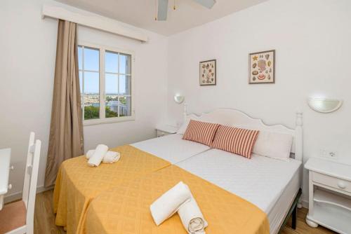 a bedroom with a large bed with a yellow blanket at Apartamento Castellsol 211 in Arenal d'en Castell